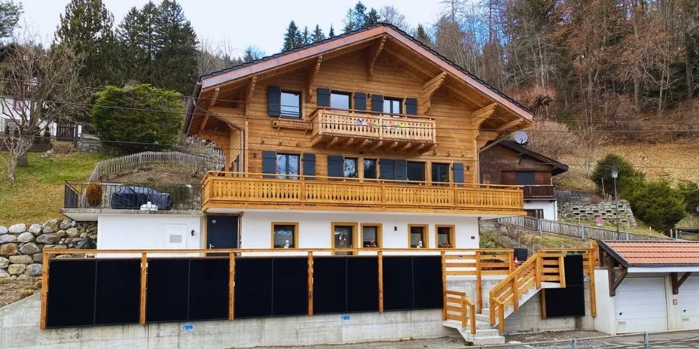 Chalet l'Adret à Gryon : Intégration de panneaux solaires en balustrade pour production hivernale. Ingénierie photovoltaïque par impulse.